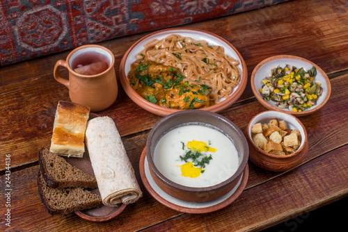 Middle Eastern cuisine dishes in ceramic plates on a wooden table.  photo