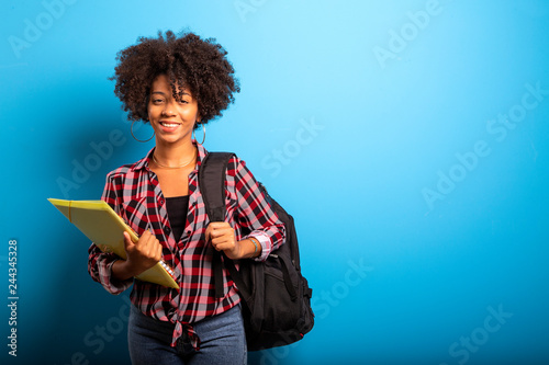 Obraz na płótnie young african student with backpack on the back on blue background w salonie