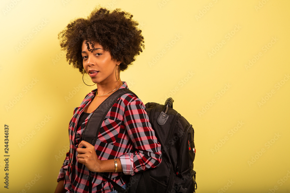 young african student with backpack on the back on yellow background young african student with backpack on the back on yellow background