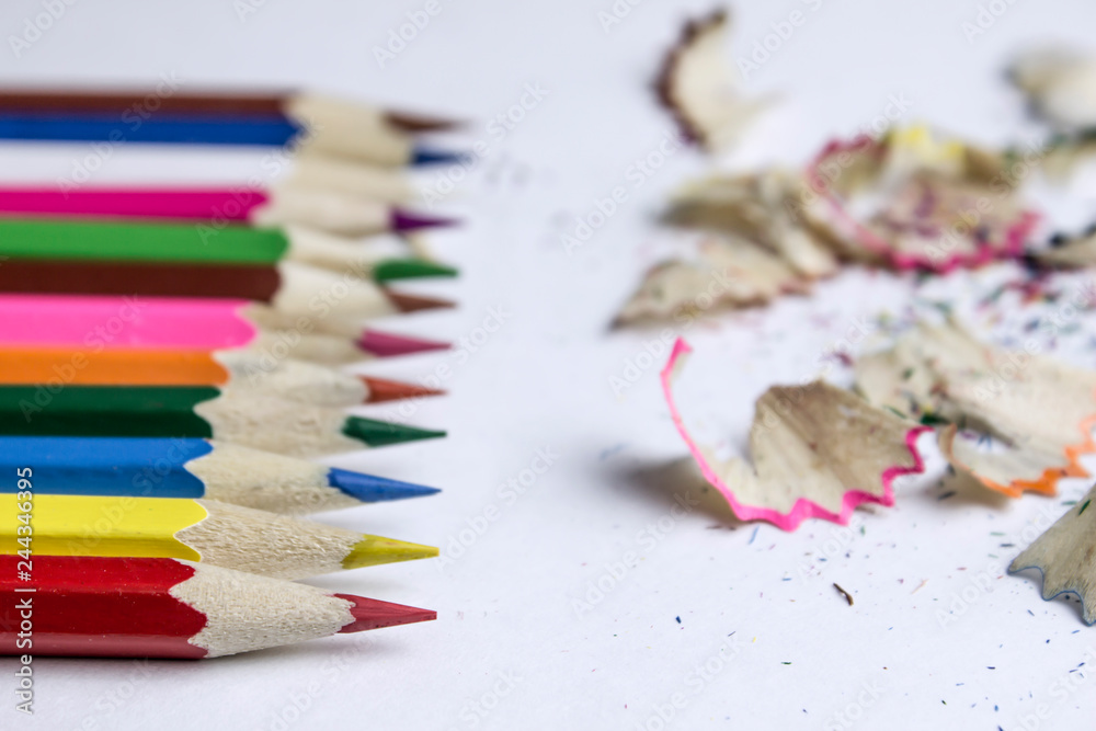 On the white table are colored pencils and sawdust On the white table are colored pencils and sawdust