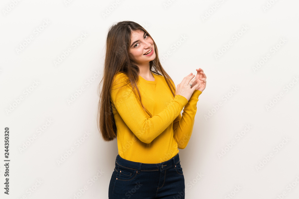 Young woman with yellow sweater applauding after presentation in a conference