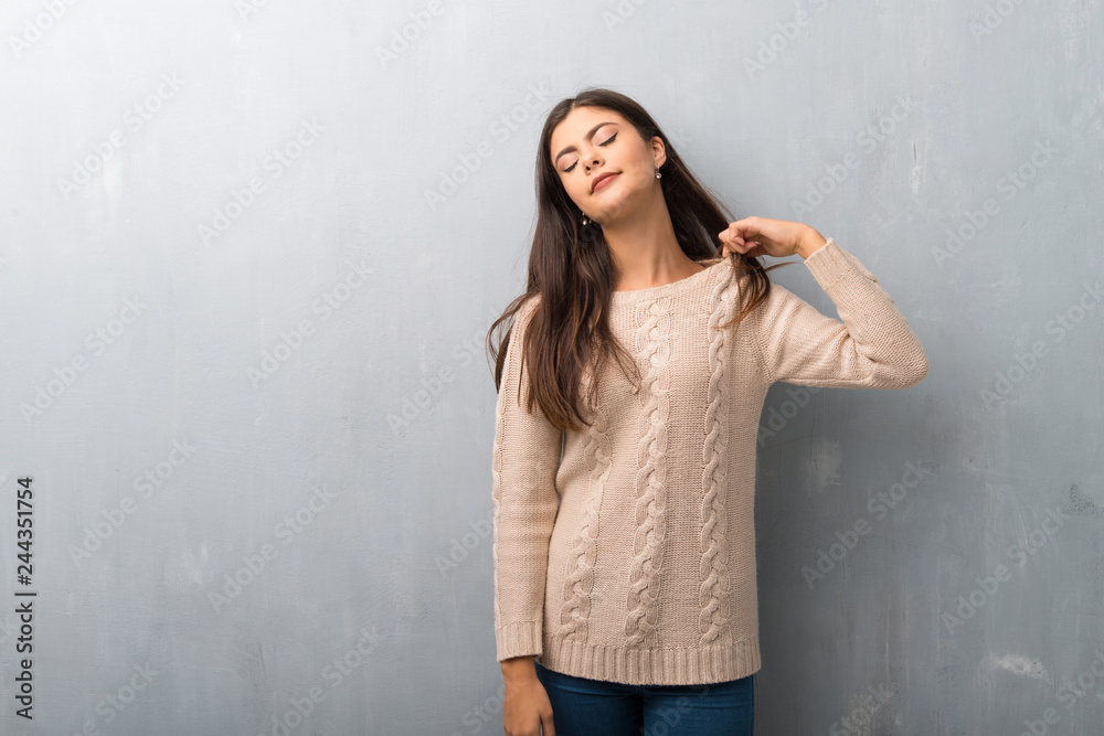 Fototapeta premium Teenager girl with sweater on a vintage wall with tired and sick expression
