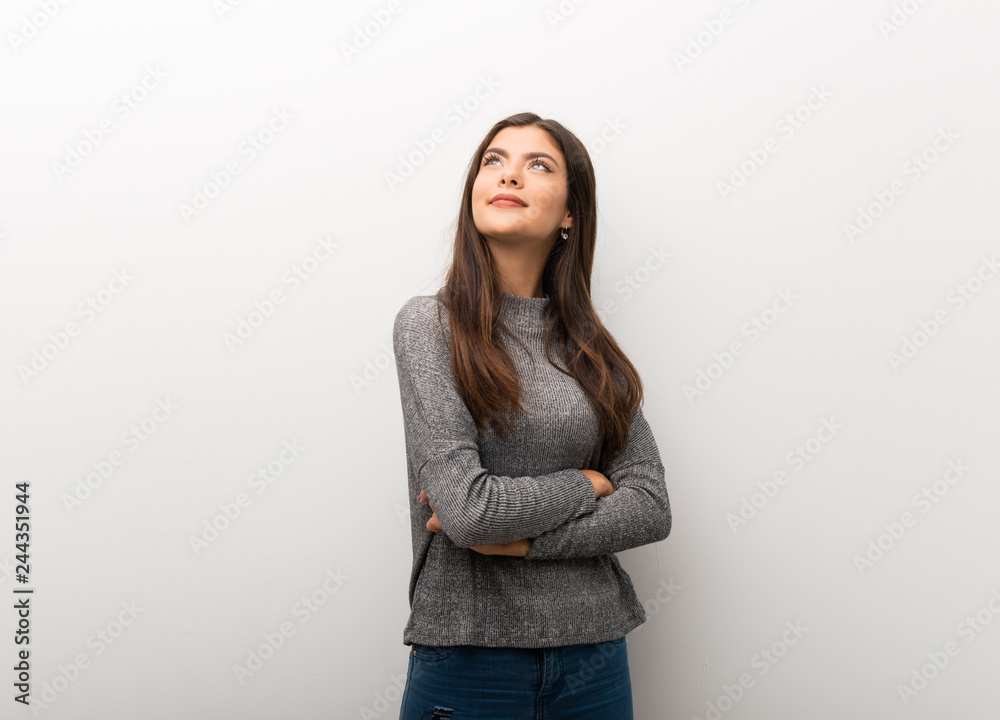 Teenager girl on isolated white backgorund looking up while smiling Teenager girl on isolated white backgorund looking up while smiling