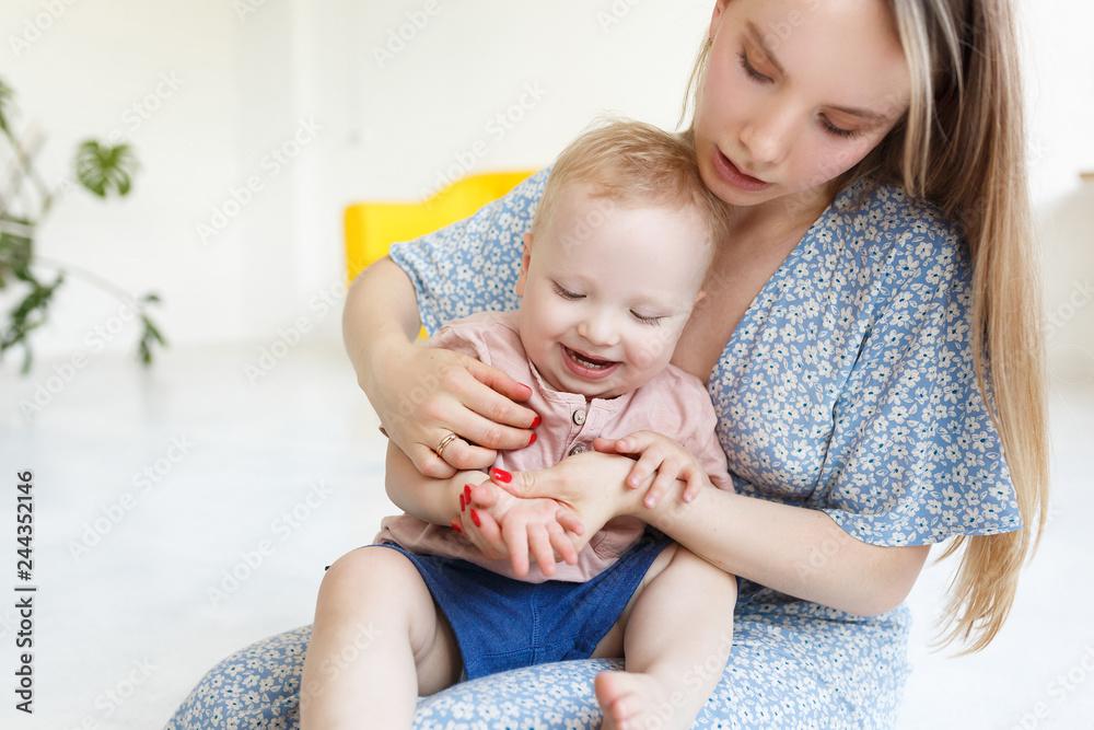 Concept of love and caring for the little kids. Pretty young mother teaches her charming one and a half year old baby counting on fingers Concept of love and caring for the little kids. Pretty young mother teaches her charming one and a half year old baby counting on fingers