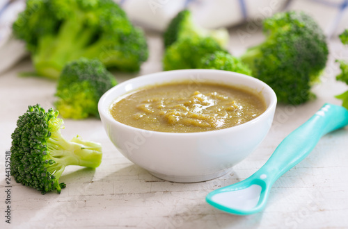 Baby food. Bowl of broccoli puree with ingredients for cooking