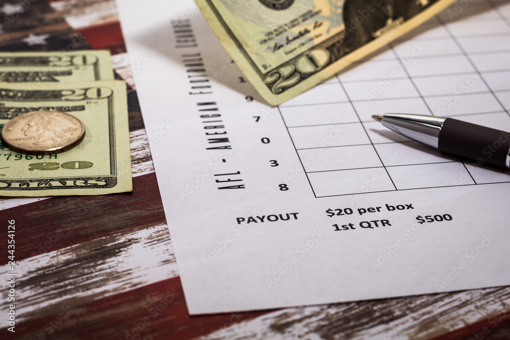 Football American office pool grid for sports betting concept with boxes, dollars, pen - blank grid Football American office pool grid for sports betting concept with boxes, dollars, pen - blank grid