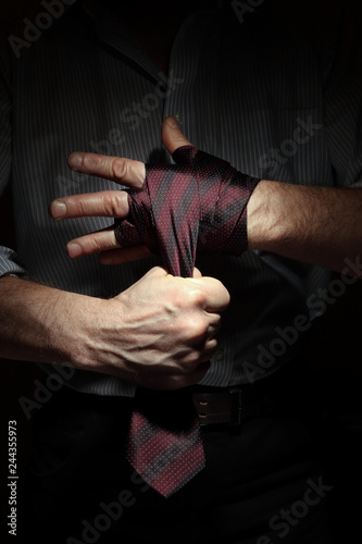 Image of man getting ready for office fight with a tie on his fist