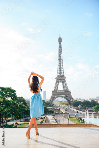 Girl in Paris looks at the Eiffel tower. No face visible. Girl is standing with her back ti the camera and no face visible. © Anna