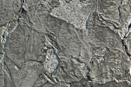 Peeling black paint on a concrete wall. Abstract background. 