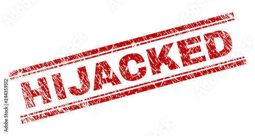 HIJACKED seal print with corroded effect. Red vector rubber print of HIJACKED text with scratched texture. Text label is placed between double parallel lines.