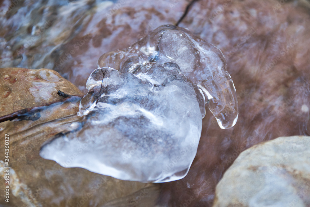 Gefrorenes Wasser im Bachbett mit Steinen