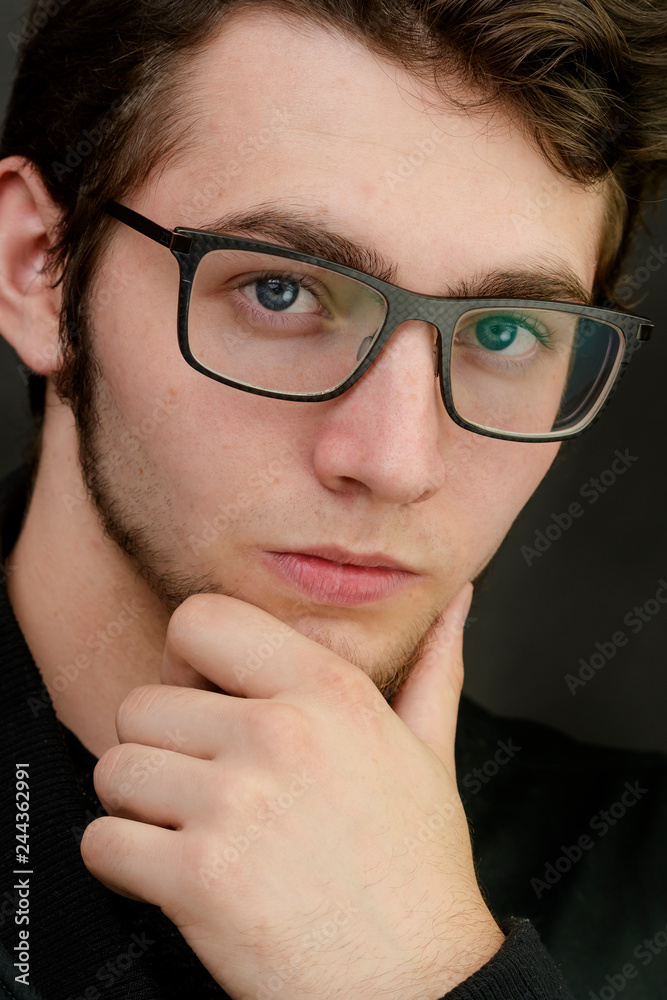 Portrait of a smart young businessman with glasses on the black background Portrait of a smart young businessman with glasses on the black background