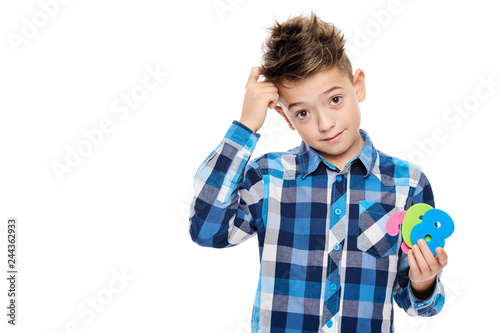 Cute boy with dyscalculia holding large colorful numbers and scratching his head. Learning disability concept on white background. photo