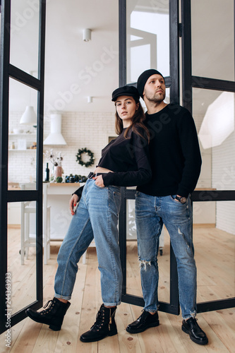 Two hipster models: a man and a woman in a blank black t-shirt, jeans and posing. in a black hat, cap, love, kisses © boykovi1991