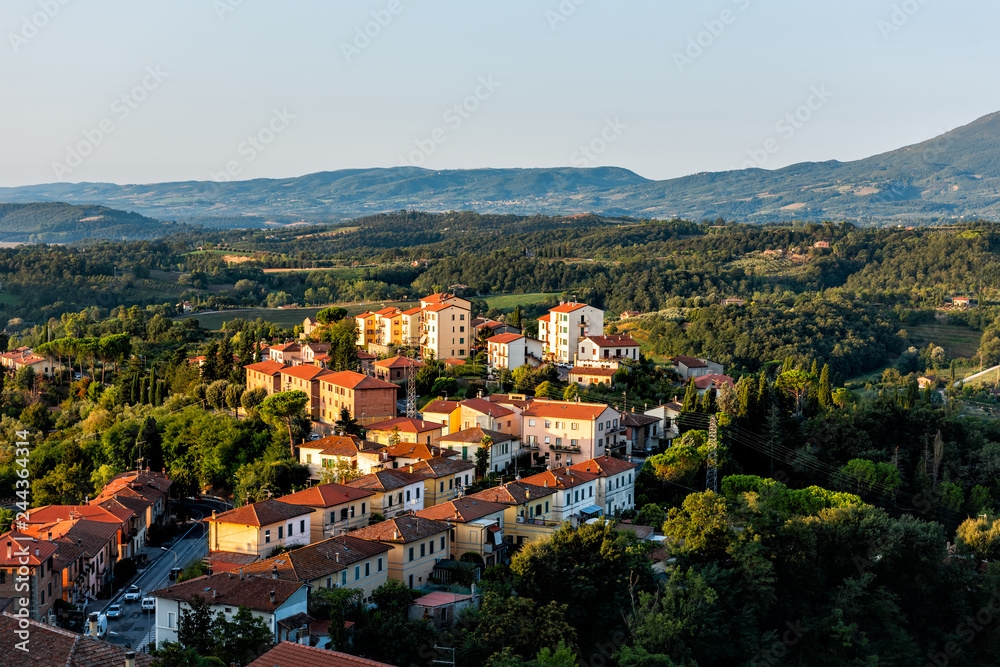Chiusi village cityscape at sunrise in Umbria Italy street road cars and rooftop houses on mountain countryside and rolling hills