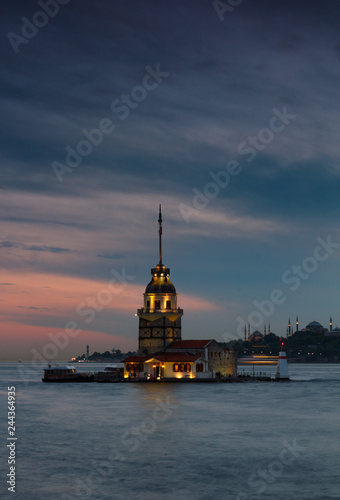 Beautiful landscape of Maiden's tower (Tower of Leandros) at sunset. View of Dramatic cloudy sky. In the distance are such landmarks as Hagia Sophia, Blue Mosque and Topkapi Palace. Istanbul. Turkey.
