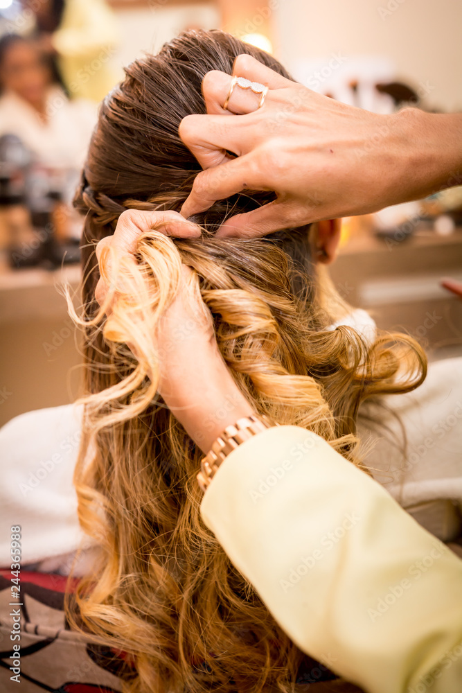 Fototapeta premium mulher fazendo o cabelo antes do casamento em frente ao espelho