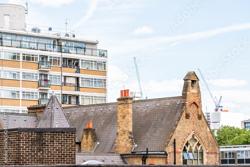 London, UK Churchill Gardens neighborhood in Pimlico with old vintage historic traditional style flats buildings and historic St Gabriel's Primary School photo