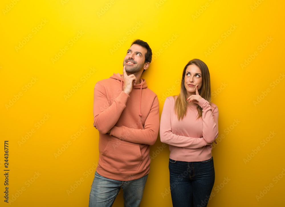 Group of two people on yellow background thinking an idea while looking up Group of two people on yellow background thinking an idea while looking up
