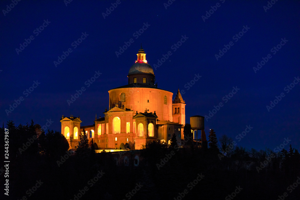 Closeup of scenic Sanctuary of Blessed Virgin of San Luca on Colle della Guardia in Bologna illuminated by night. Historical church and pilgrimage destination in Emilia-Romagna, Italy. Famous landmark
