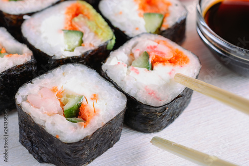 Sushi rolls made from rice, shrimp, flying fish roe and nori, cooked in a fast delivery cafe