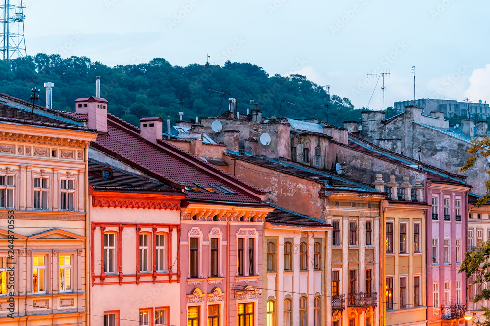 Historic Lviv, Ukraine cityscape with colorful architecture buildings in old town market square in evening night illuminated multicolor houses