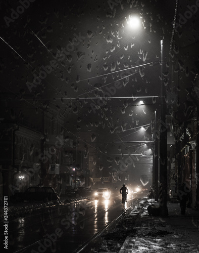 Cyclist on a night street in the rain