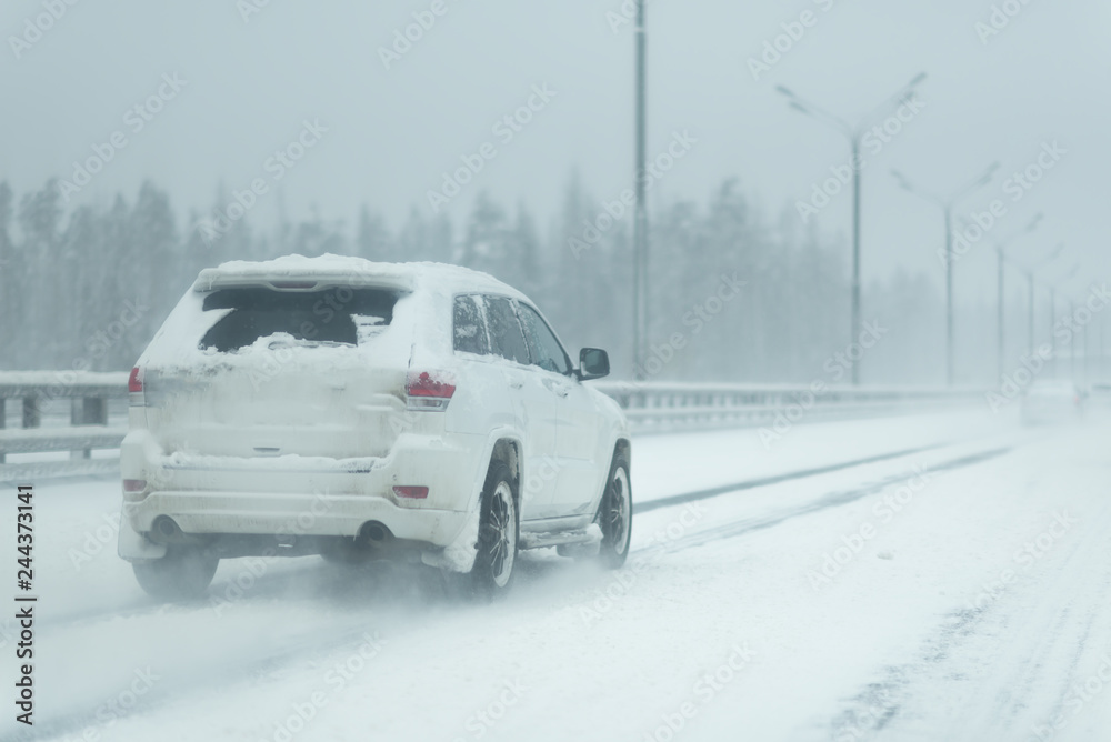 Car driving on a heavy winter road