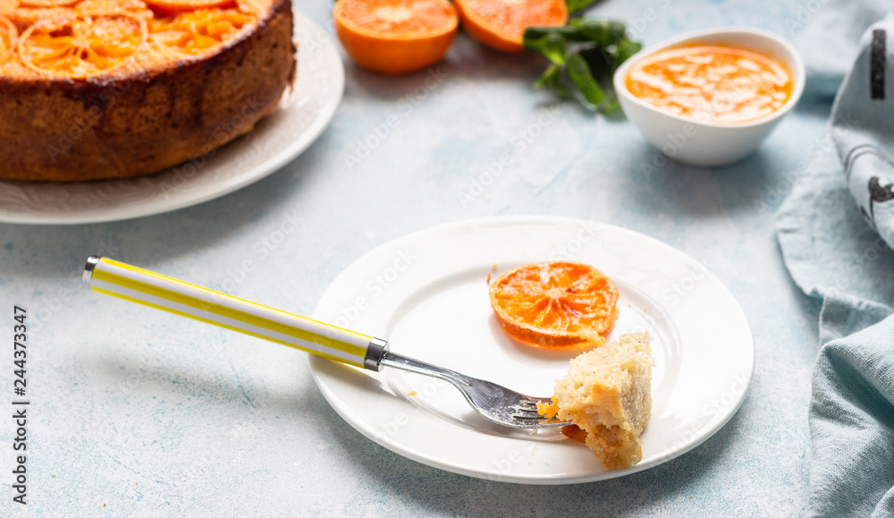 Upside down tangerine cake on a sky blue stone or concrete background. Upside down tangerine cake on a sky blue stone or concrete background.