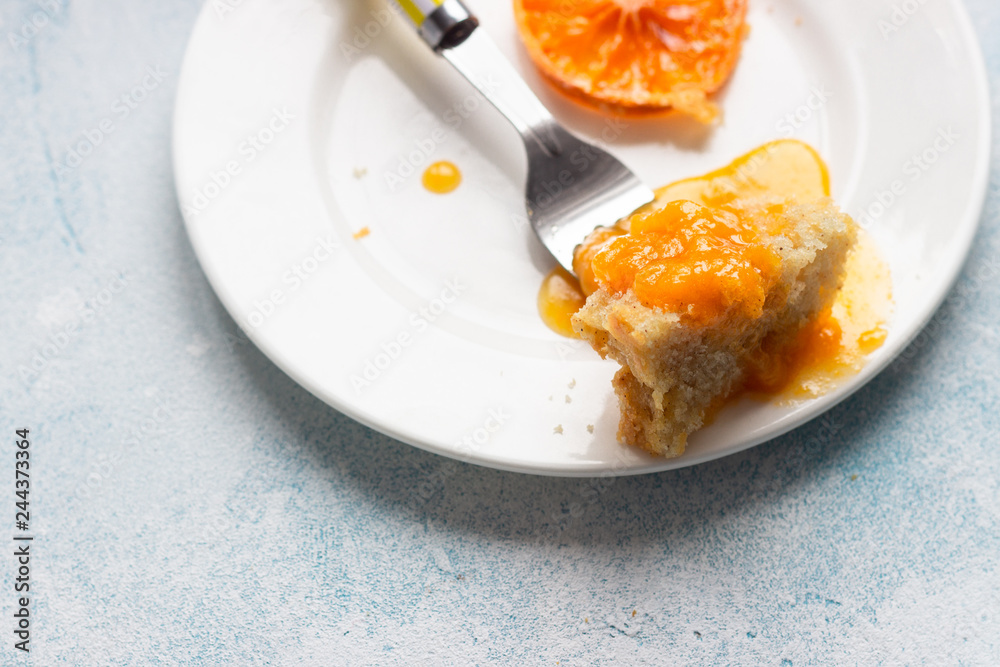 Upside down tangerine cake on a sky blue stone or concrete background.