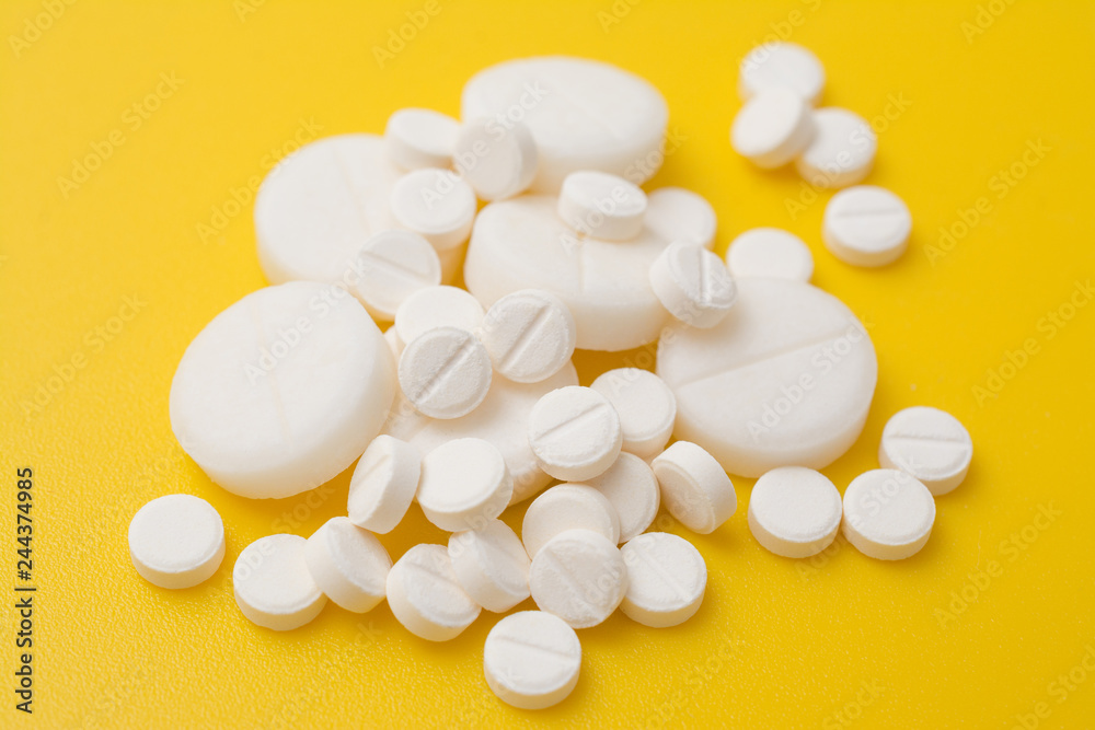 The antibiotic pills dose on a yellow background closeup The antibiotic pills dose on a yellow background closeup