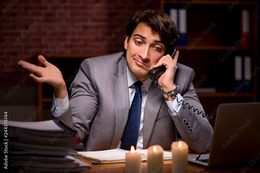 Businessman working late in office with candle light Businessman working late in office with candle light