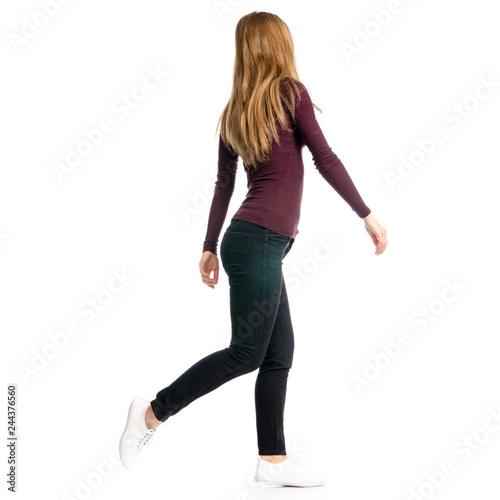 Woman in black jeans and shirt run goes walking on white background isolation, back view