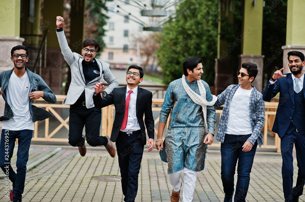 Group of six south asian indian mans in traditional, casual and business wear walking dancing and having fun together.