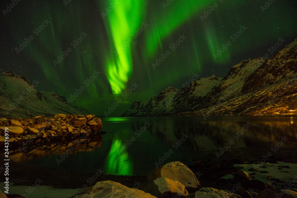 Green nordic lights, aurora borealis, at Erstfjordsbotn, Kvaloya, Tromso, Norway with mountains and a fjord