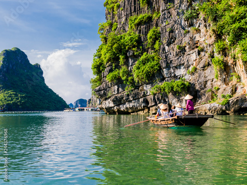 Tourists enjoying a boat trip through the limestone mountains of halong bay 