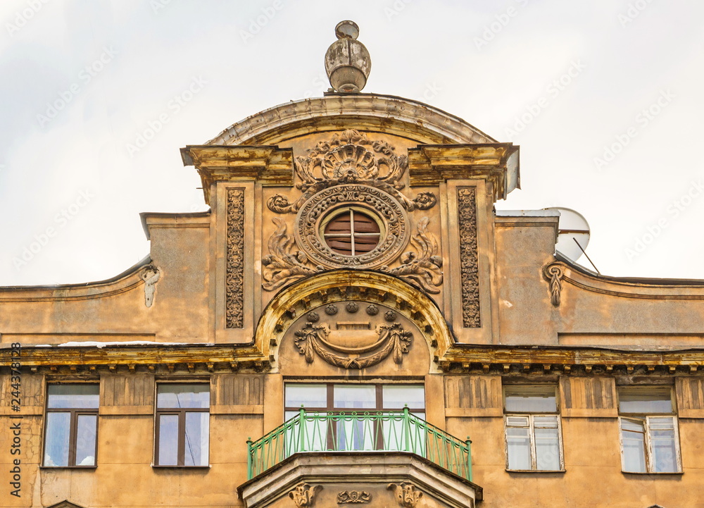 Fototapeta premium Fragment of the facade of an old house with a tower, stucco and a balcony