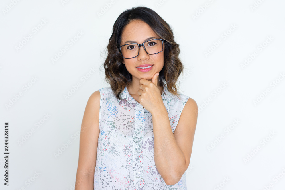 Positive smart Asian girl in eyeglasses posing at camera. Portrait of beautiful young woman wearing glasses, touching chin and looking at camera. Glasses wearing concept Positive smart Asian girl in eyeglasses posing at camera. Portrait of beautiful young woman wearing glasses, touching chin and looking at camera. Glasses wearing concept