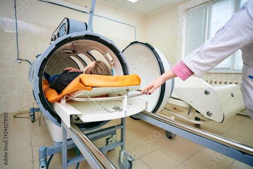 Fotografie the guy in the black T-shirt lies in the hyperbaric chamber, oxygen therapy, med