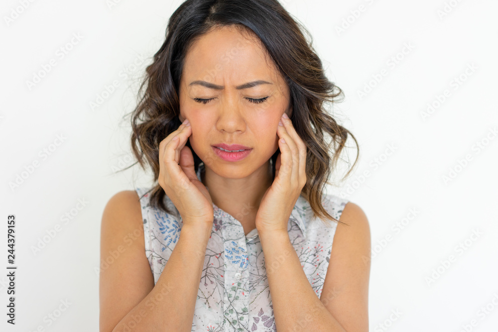 Worried young woman frowning and touching cheeks. Pretty Asian lady having toothache. Dental care concept. Isolated front view on white background. Worried young woman frowning and touching cheeks. Pretty Asian lady having toothache. Dental care concept. Isolated front view on white background.