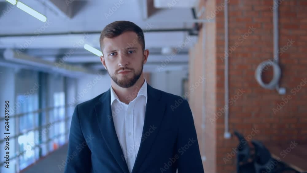successful businessman walking in loft office. handsome man wearing elegant blue suit and white shirt slow motion indoors successful businessman walking in loft office. handsome man wearing elegant blue suit and white shirt slow motion indoors