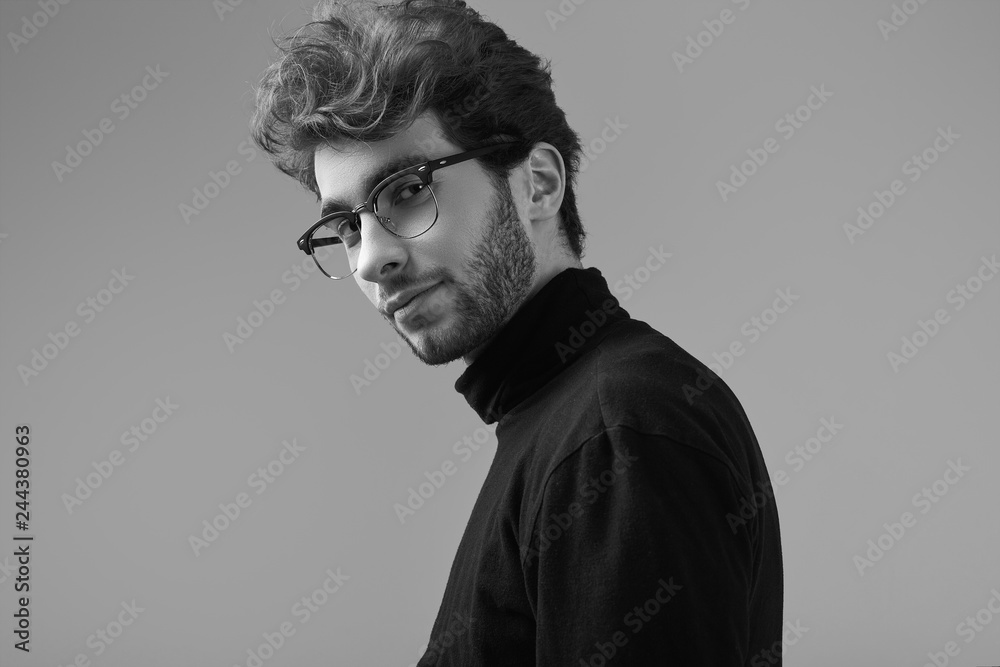 Handsome elegant man with curly hair wearing black turtleneck and glasses Handsome elegant man with curly hair wearing black turtleneck and glasses