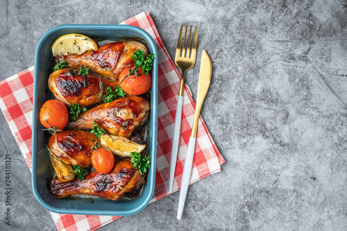 baked chicken legs in a barbecue sauce with tomatoes,  top view