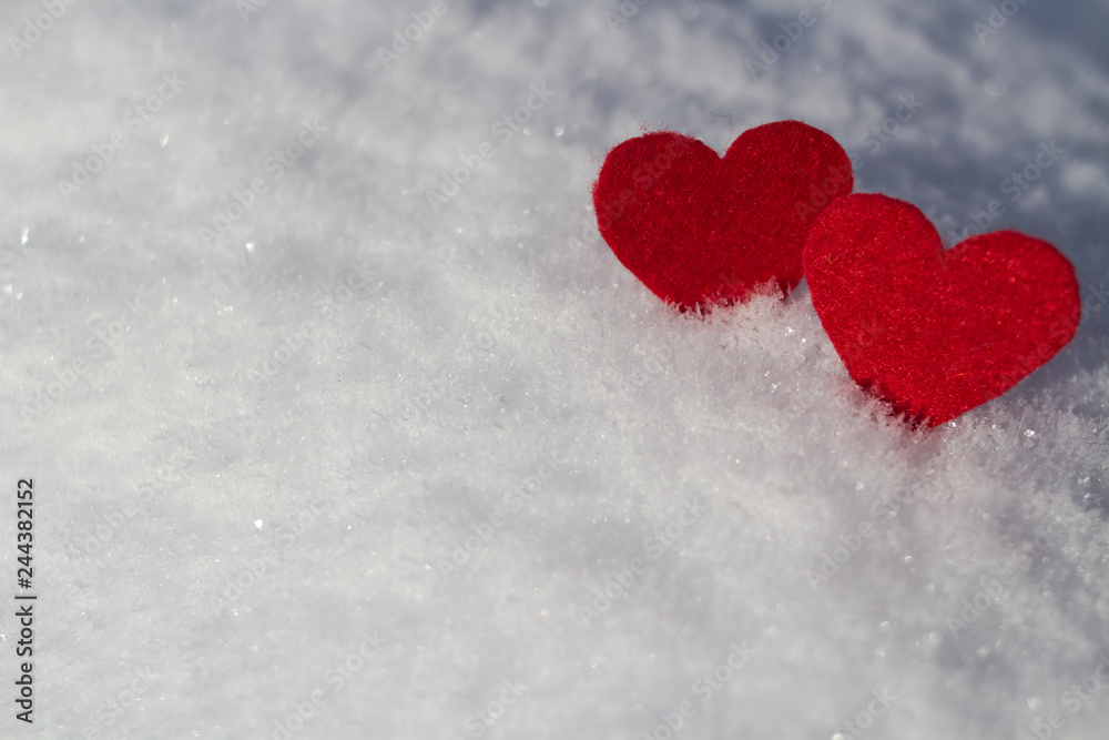 red hearts lie on fluffy snow a white background