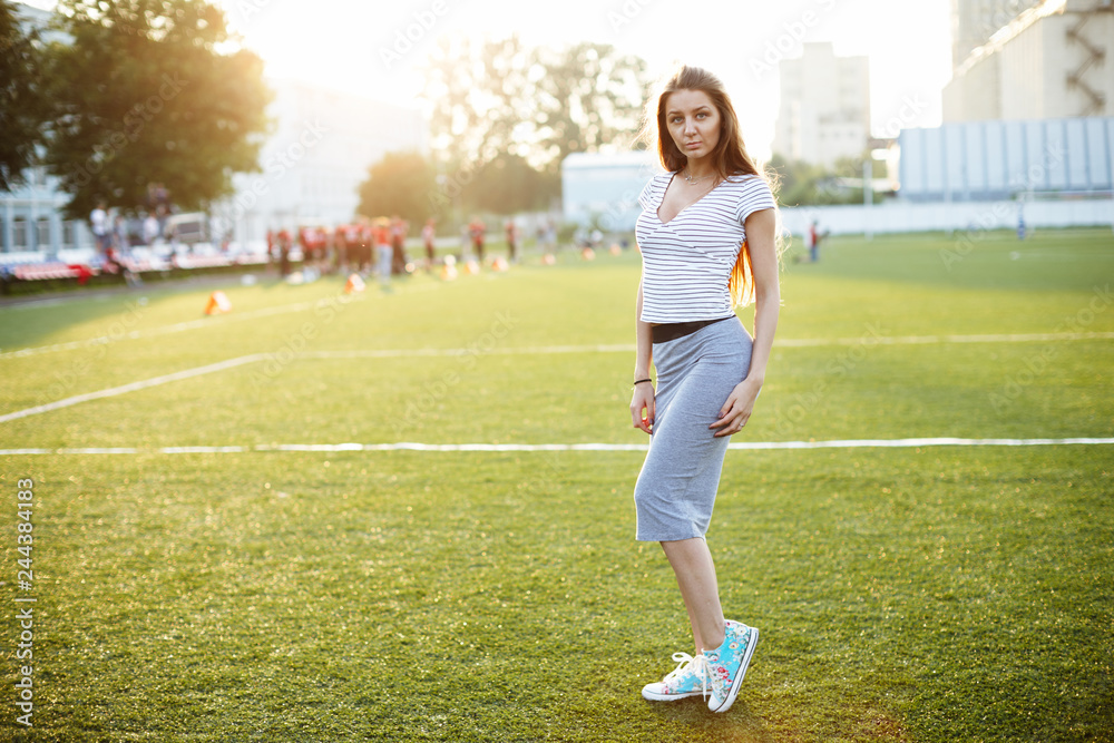 Beautiful girl posing for photo on sports playground at sunset Beautiful girl posing for photo on sports playground at sunset