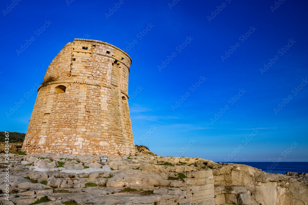 The ancient watch tower of Porto Miggiano, built on the cliffs overlooking the sea. Bleak and rocky landscape with a splendid view of the sea. Santa Cesarea Terme, Puglia, Salento, Italy.