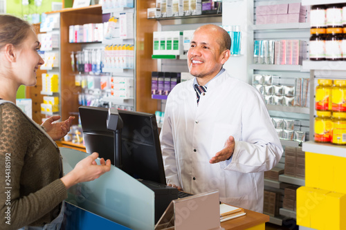 Pharmacist serving client in pharmacy .