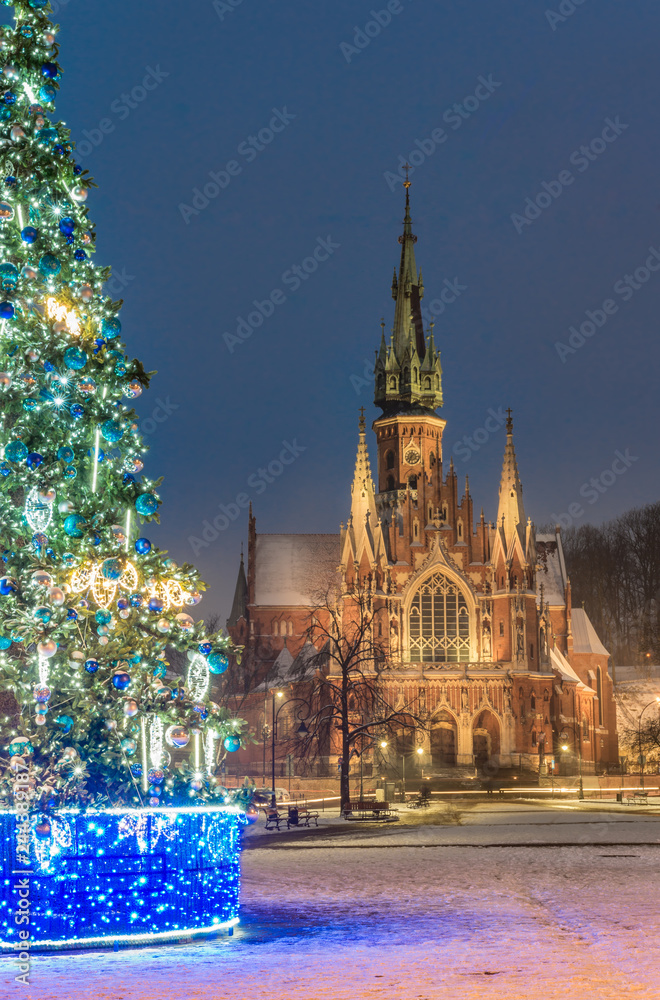 Obraz premium Krakow, Poland, Christmas tree on Podgorze Market Square and St Joseph church