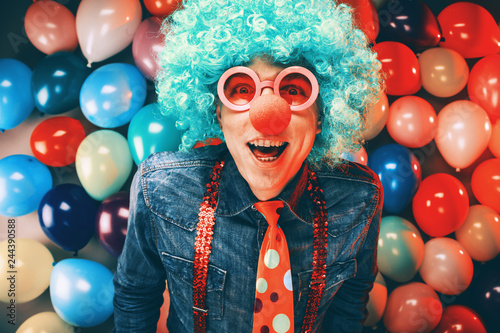 Mann in Karnevalstimmung auf einem Hintergrund aus bunten Lüftballons 