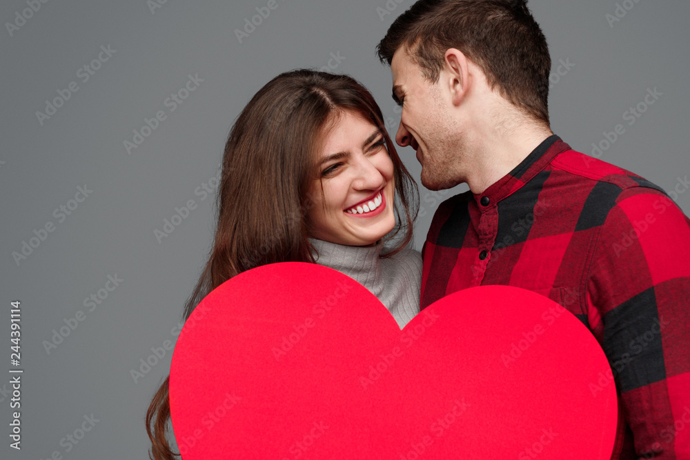 Laughing couple holding huge heart Laughing couple holding huge heart